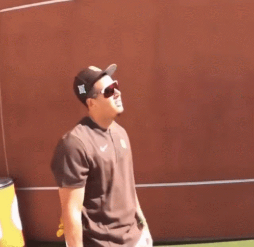 Man With Hat and Sunglasses at Red Wall