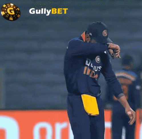 Man With Head Down In Front Of Gullybet Ad GIF