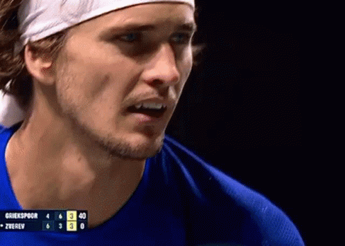 Man With Headband and Blue Shirt at Scoreboard