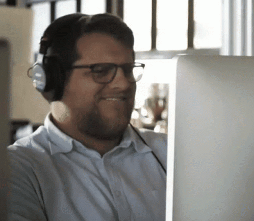 Man with Headphones and Glasses Looking at Computer