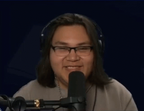Man With Headphones and Glasses Thumbs Up at Microphone