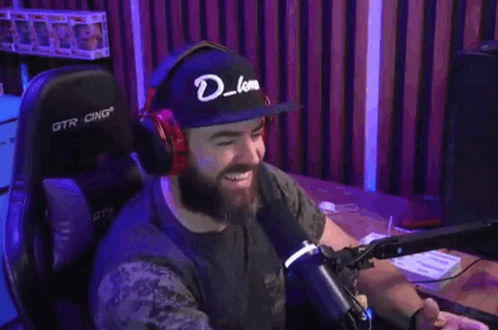 Man With Headphones and Hat With Letter D at Microphone