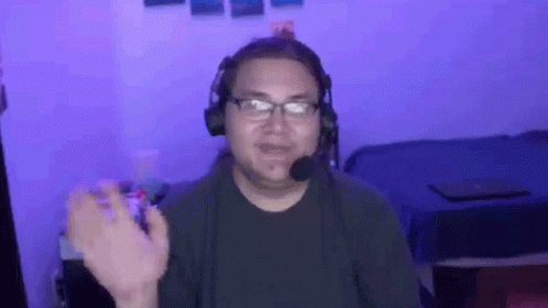 Man With Headphones and Microphone Sitting in Front of Bed