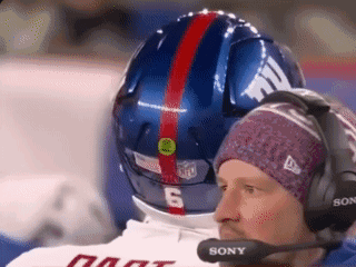 Man with Headphones and Sony Microphone Looking at Football Helmet