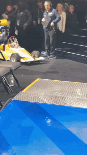 Man with Headphones and Yellow Race Car