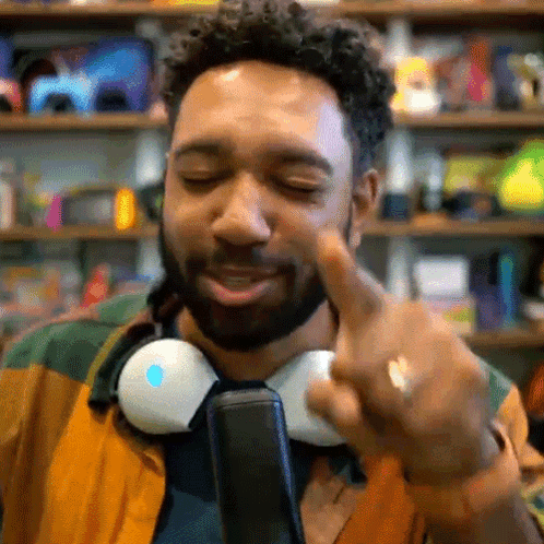 Man With Headphones Around Neck Pointing