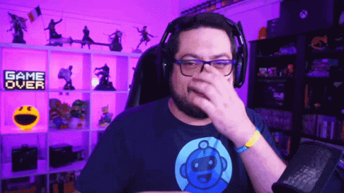 Man With Headphones Covering Nose In Front Of Game Over Sign GIF