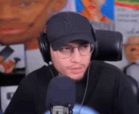 Man With Headphones Hat and Glasses at Microphone