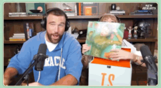 Man With Headphones Holding Book Woman With TS Box
