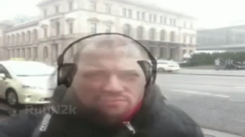 Man With Headphones In Front Of Building GIF