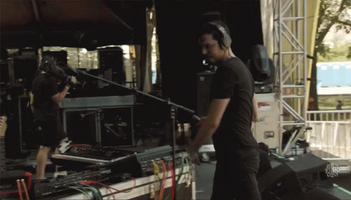 Man With Headphones In Front Of Fox News Sign GIF