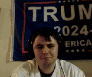 Man With Headphones in Front of Trump Sign