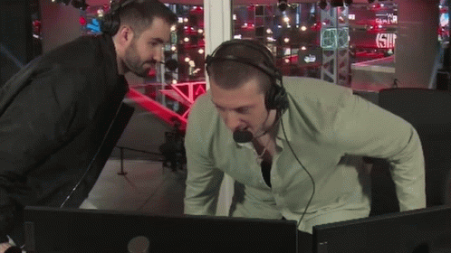 Man With Headphones Looking At Another Man At Computer GIF