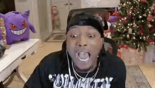 Man With Headphones Making Funny Face by Christmas Tree