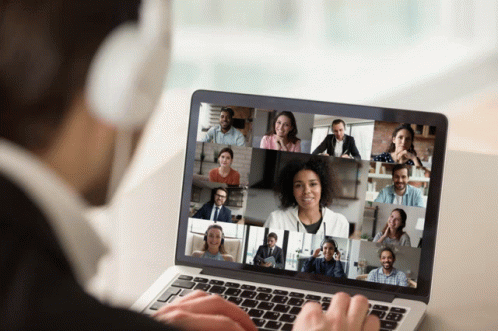 Man With Headphones on Laptop With Group of People