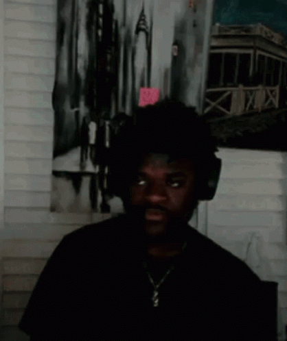 Man With Headphones Standing in Front of Painting