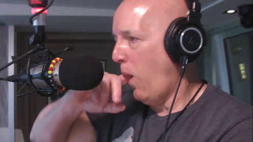 Man with Headphones Talking Into Microphone