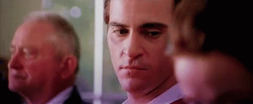 Man With Knife In Mouth Standing Next To Another Man GIF