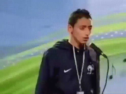 Man With Lanyard Standing At Microphone GIF