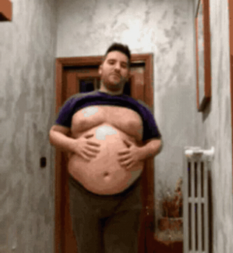 Man with Large Belly Shirtless in Hallway