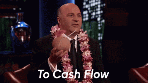 Man With Lei Holding Coconut And Straw Saying To Cash Flow GIF