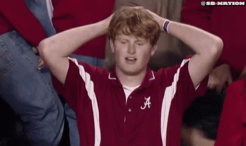 Man With Letter A on Shirt Holding Head