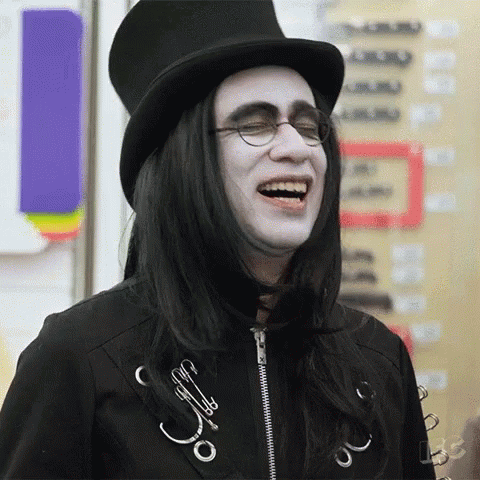 Man With Long Black Hair and Glasses in Top Hat Laughing