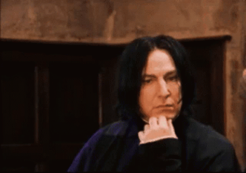 Man With Long Black Hair Hand on Chin Dark Room