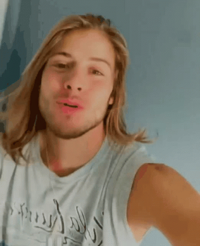 Man With Long Blonde Hair and Beard Smiling in Inspired Tank Top