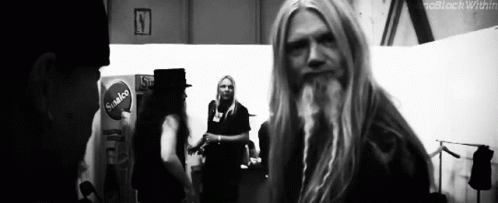 Man With Long Blonde Hair and Beard Standing in Room