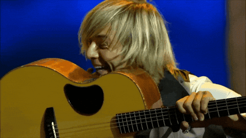 Man with Long Blonde Hair Playing Guitar