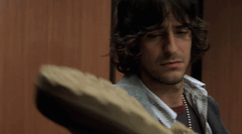 Man with Long Curly Hair Holding Bread