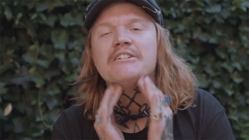 Man With Long Hair and Bandana Giving Peace Sign