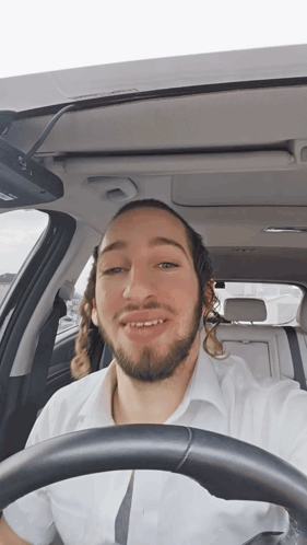 Man With Long Hair and Beard Driving Car