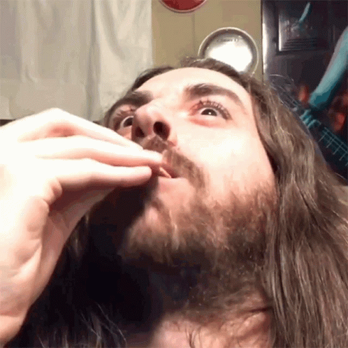 Man With Long Hair and Beard Eating