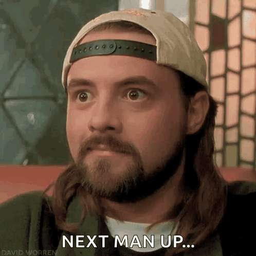 Man With Long Hair and Beard in Hat Saying Next Man Up