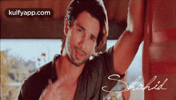 Man With Long Hair And Beard Leaning On Wall GIF