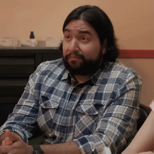 Man With Long Hair and Beard Looks at Camera