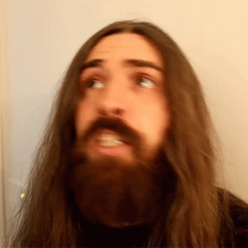 Man With Long Hair and Beard Making Face