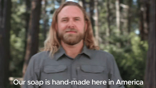 Man With Long Hair and Beard Saying Our Soap Is Hand-Made Here in America
