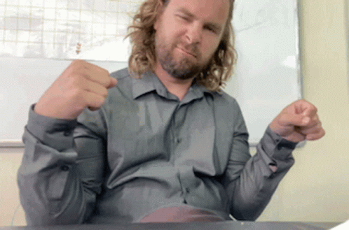 Man With Long Hair and Beard Sitting at Desk