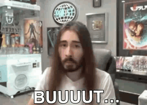 Man With Long Hair and Beard Sitting by Popcorn Machine