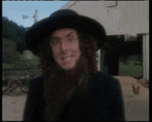 Man with Long Hair and Black Hat Smiling