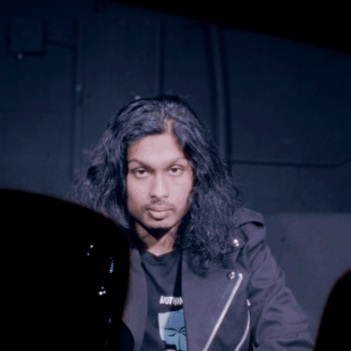 Man With Long Hair in Black Jacket Saying Nothing