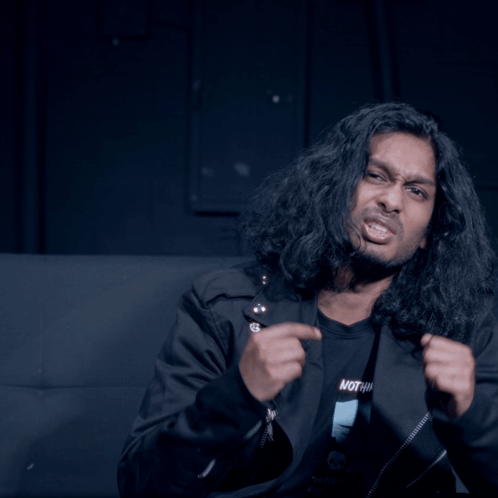 Man With Long Hair in Black Shirt Saying Nothing