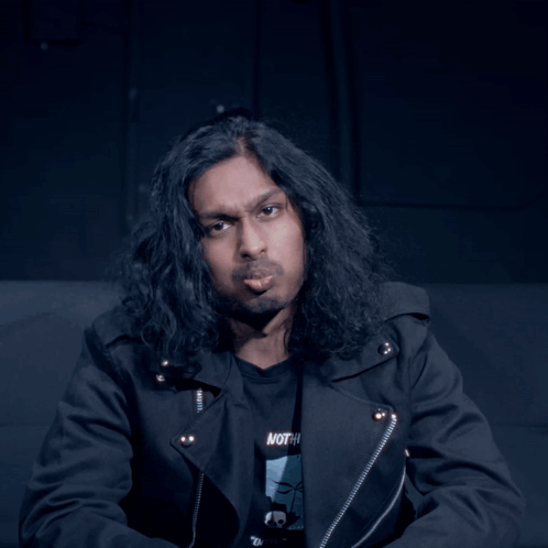 Man With Long Hair in Black Shirt Saying Nothing