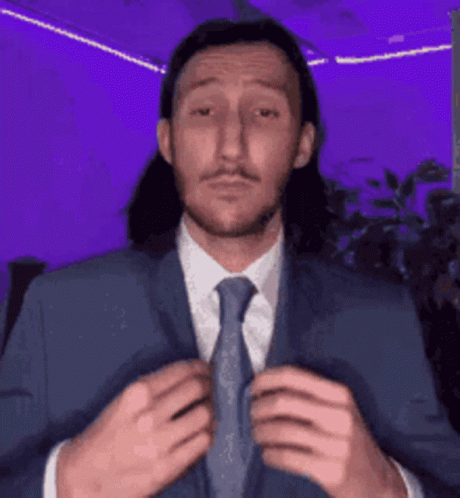 Man With Long Hair In Blue Suit And Tie GIF