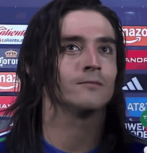 Man With Long Hair in Front of Corona Ads