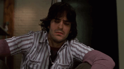 Man with Long Hair in Striped Shirt and Purple Sweater