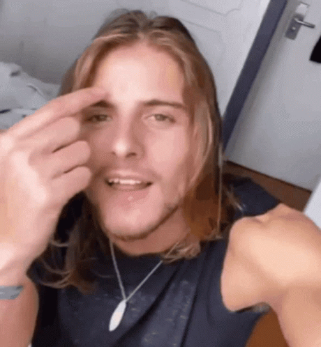 Man With Long Hair Making Funny Face With Finger